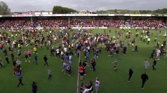 Large group of people running on a soccer field.
