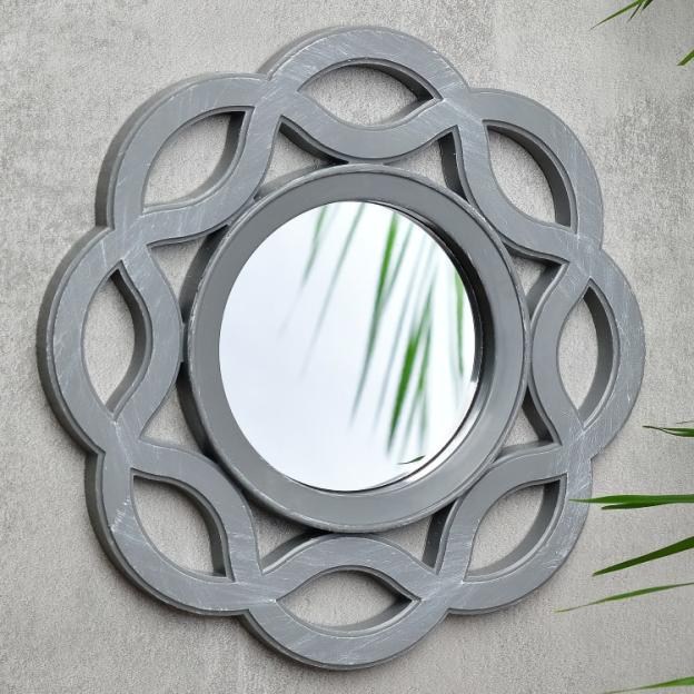 Grey round mirror with ornate frame.