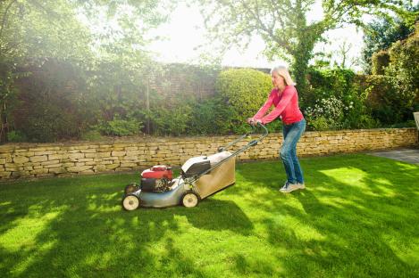 Woman mowing lawn.