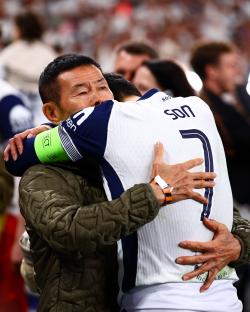 Son Heung-Min of Tottenham Hotspur embracing a man after a game.