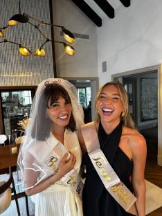 Two women at a bridal shower. One wears a veil and a