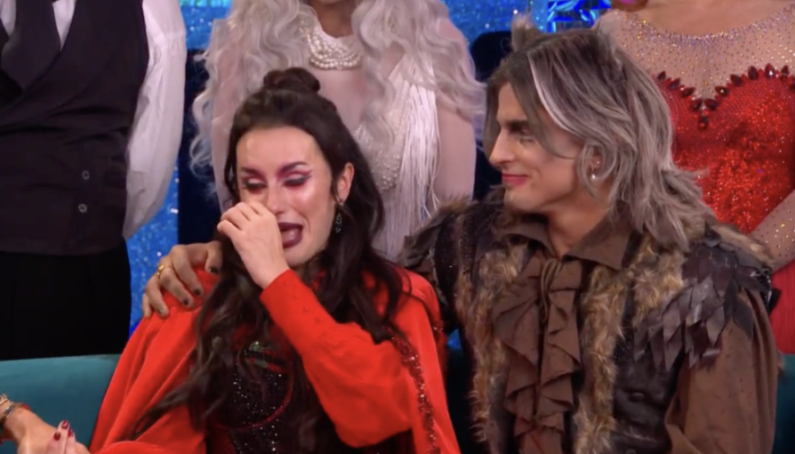 Amber Davies wiping tears from her eye, supported by another person dressed in costume.