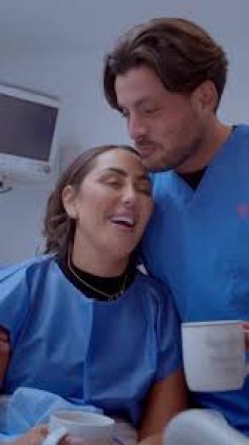 Couple embracing in hospital room.