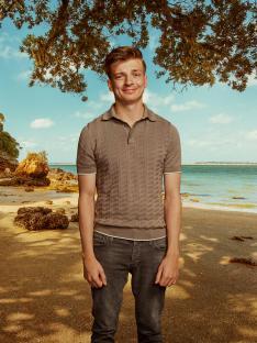 Man smiling on a beach.