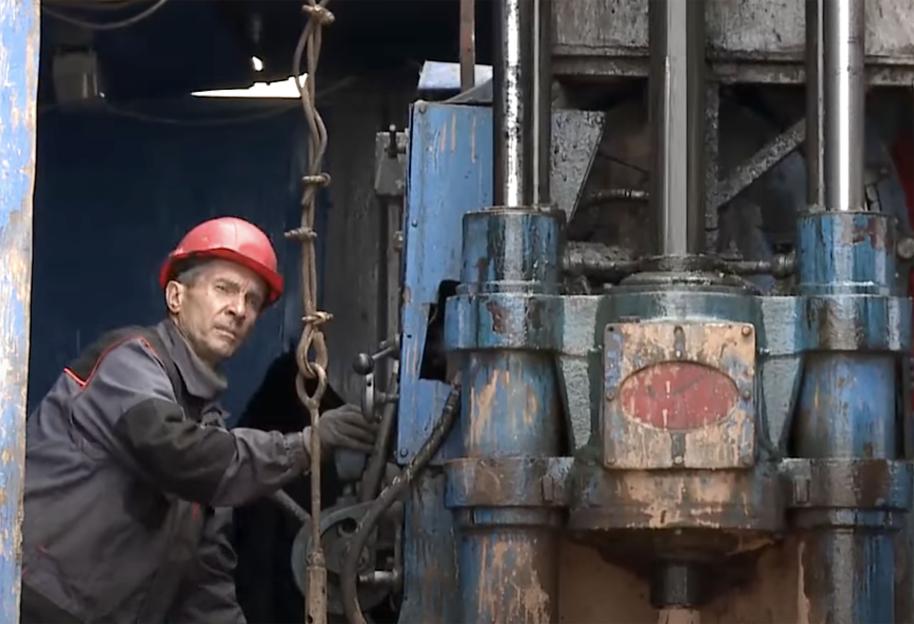 Worker operating a drilling rig.