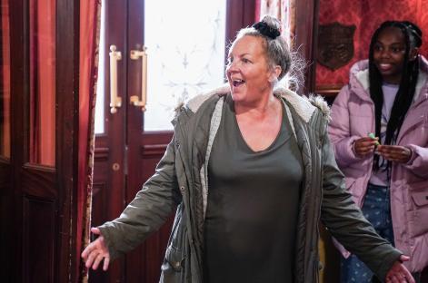 Karen Taylor from EastEnders reacting in a doorway.