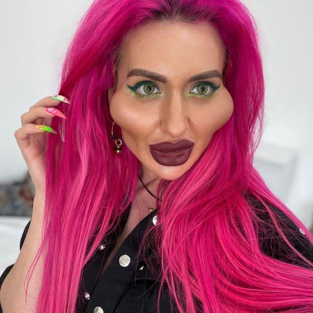Anastasia Pokreshchuk with bright pink hair, green eyes, and exaggerated cheek fillers.