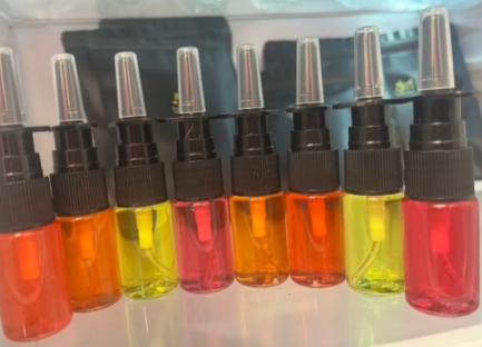 Eight bottles of colorful nasal tanning spray.