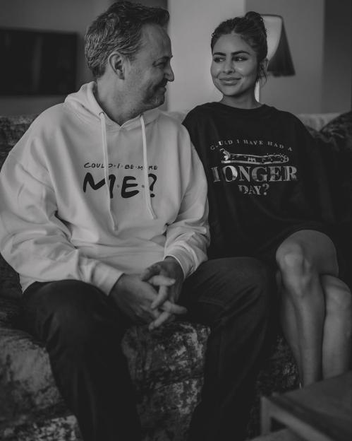 Black and white photo of Matthew Perry and Briana Brancato sitting together on a couch.
