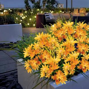Solar-powered yellow flower lights in a garden planter.