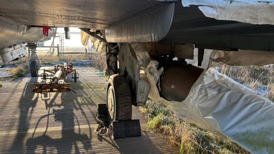 Underside of a damaged Hawker Hunter jet in a plane graveyard.