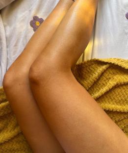 Sun-kissed legs on a yellow blanket.