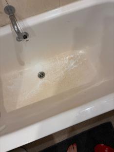 Bath tub with orange residue.
