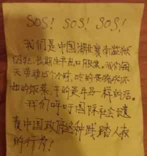 Photo of a note written in Chinese and English that reads "SOS! SOS! SOS!" and details allegations of forced labor in a Chinese prison.