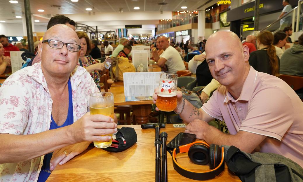 Two men sharing beers at a pub.