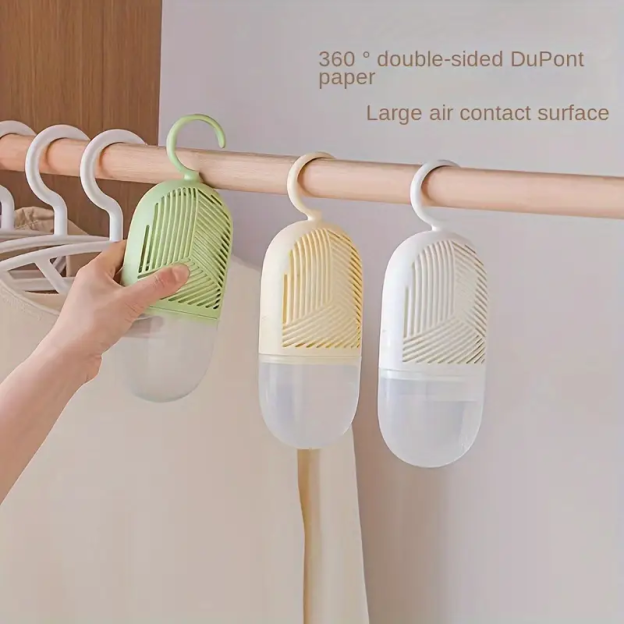 Three hanging dehumidifiers in green, beige, and white.