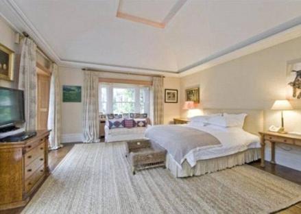 Spacious bedroom with large bed and bay window.