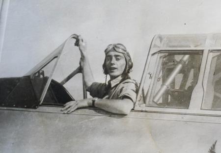 Black and white photo of a pilot in a cockpit.