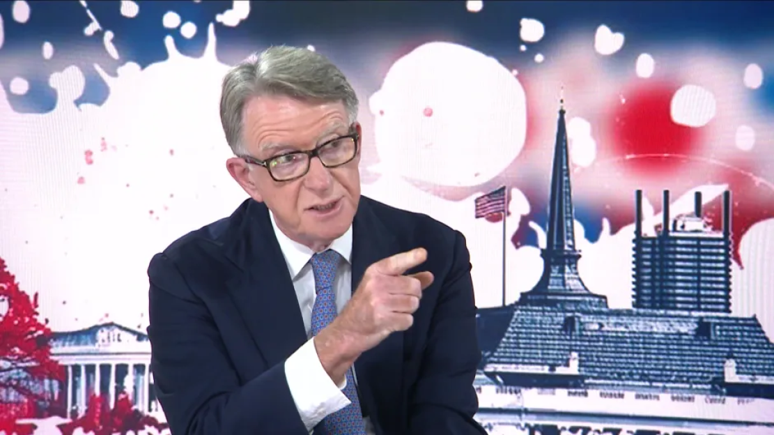 Man in suit speaking, gesturing.