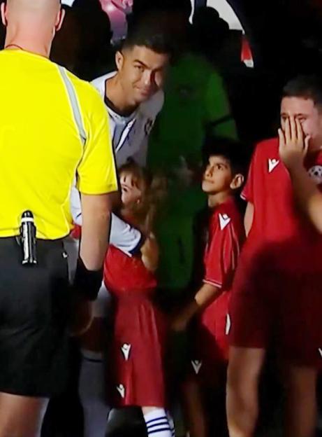 Cristiano Ronaldo comforts a crying young mascot.