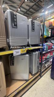 Silver suitcases on a Tesco shelf.
