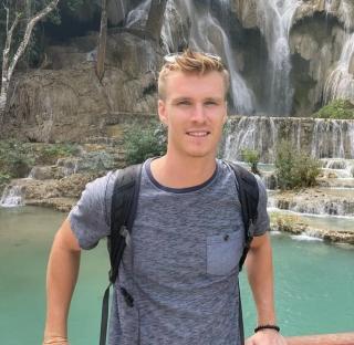 Man in front of a waterfall.