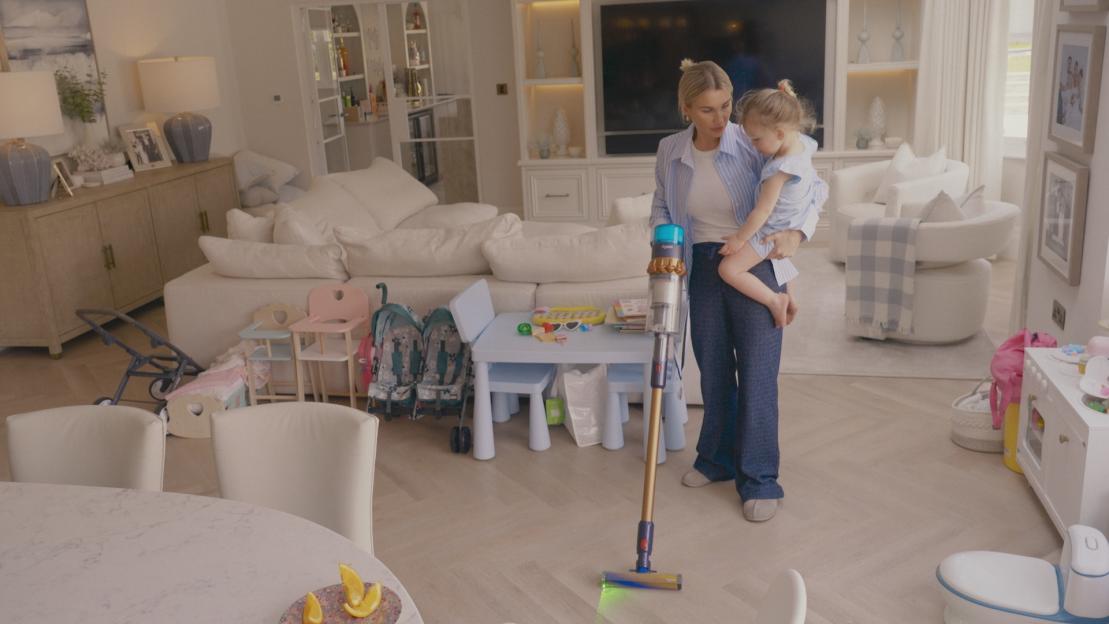 Sam and Billie Faiers with a toddler, vacuuming their living room.