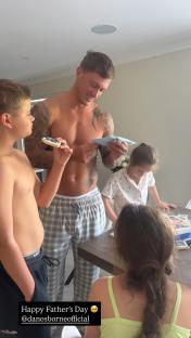 A man opens Father's Day gifts from his children.
