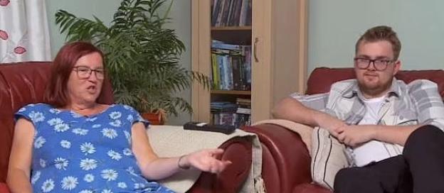 A woman and a man sitting in armchairs, talking.