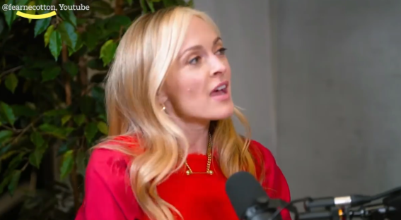 Woman in red speaking into a microphone.