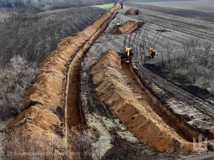 Aerial view of excavators digging anti-tank ditches.