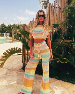 Woman in striped knit pants and top by the pool.