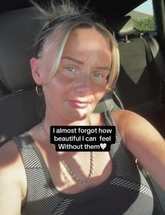Woman in a car, smiling and wearing a gold necklace.