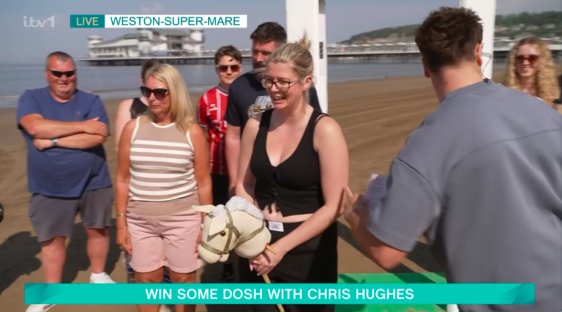 Chris Hughes on a beach with people playing a game.