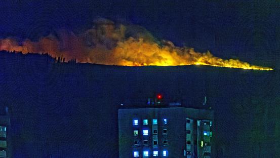 Wildfire at night, viewed from a city building.