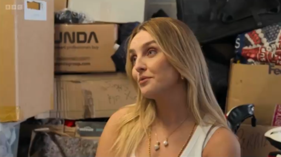 Woman with long blonde hair looking to the side, surrounded by moving boxes.