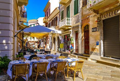 Outdoor cafe tables and chairs on a sunny street in an old village.