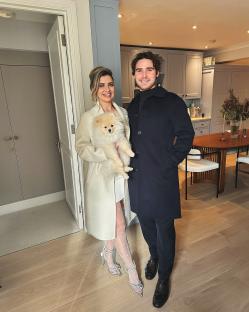 Photo of a couple and their dog in their home.