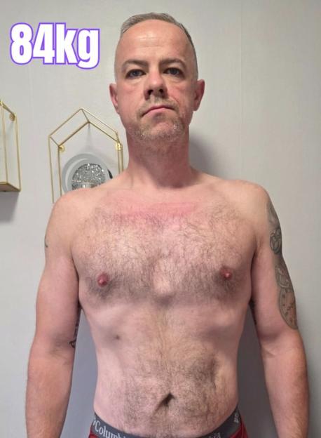 Shirtless man with 84kg overlaid.