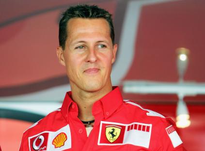 Michael Schumacher smiling in a Ferrari racing shirt.