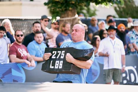 Mitchell Hooper competing in the World's Strongest Man competition, lifting a 275 lbs weight.