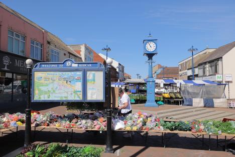 Redcar market scene with a welcome sign and clock tower.