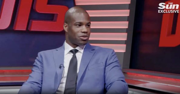 Screenshot of a man in a blue suit being interviewed.