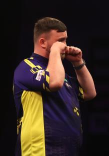 Luke Littler reacting during a darts match.