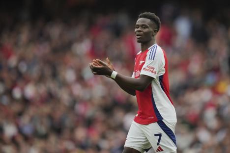 Arsenal's Bukayo Saka applauding during a soccer match.