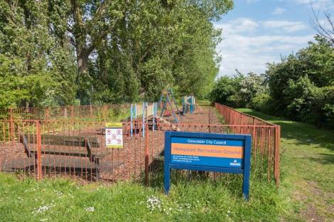 Hempsted Recreation Ground playground with playground equipment and benches.