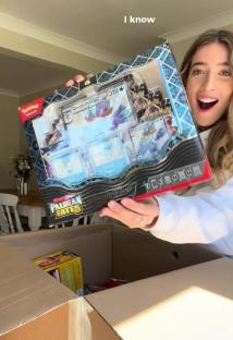 Woman holding a Pokémon Paldean Exates box.