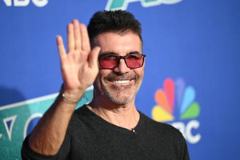 Simon Cowell waving at the America's Got Talent Season 20 red carpet.