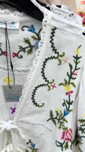 Close-up of embroidered white top with floral details.