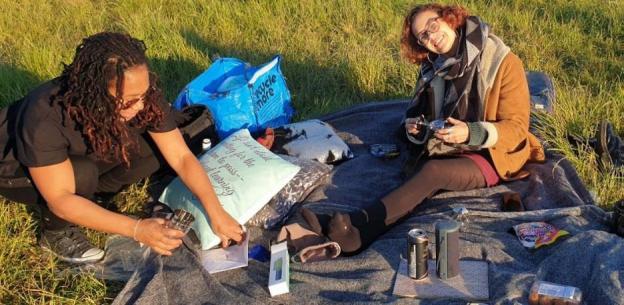 Two women at a picnic in a park.